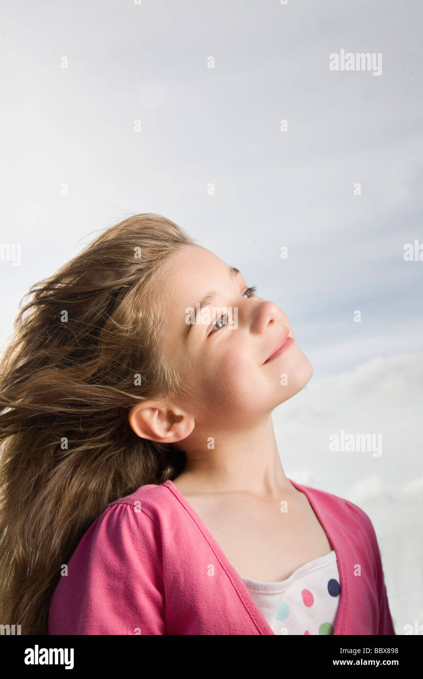 Young girl looking up to the sky smiling Stock Photo - Alamy