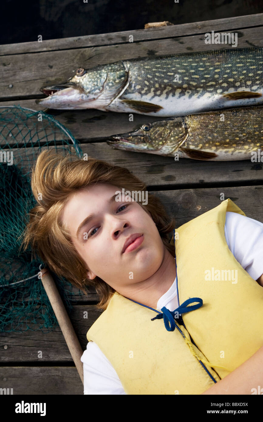 A boy with a fish on a jetty Sweden. Stock Photo