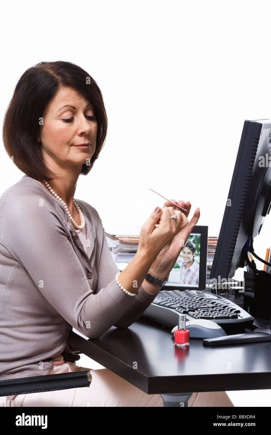 A woman doing her nails at the office Stock Photo Alamy