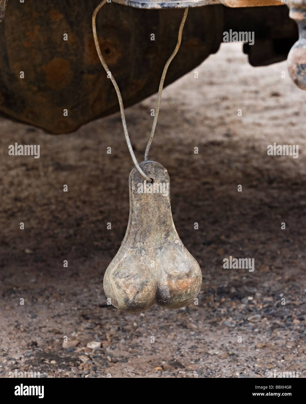 brass balls hang from rear bumper of pickup truck in rural North