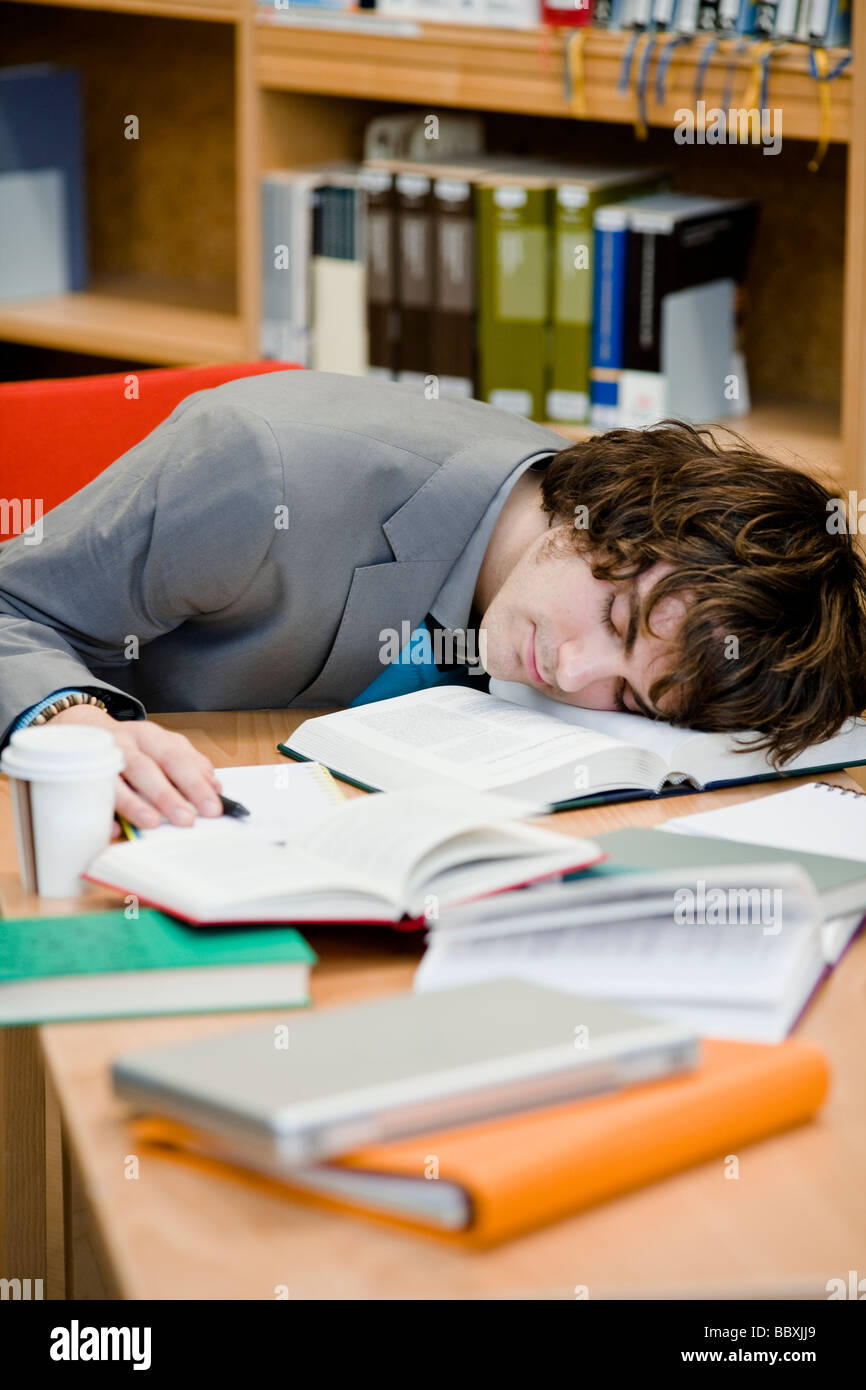 A student who has fallen asleep in a library Sweden. Stock Photo