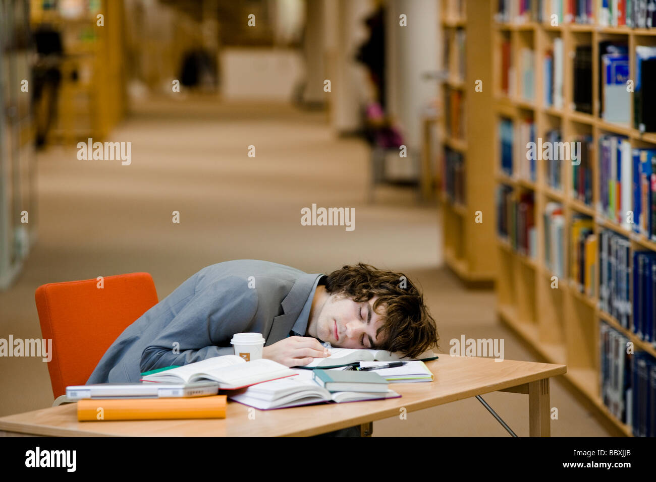 A student who has fallen asleep in a library Sweden. Stock Photo