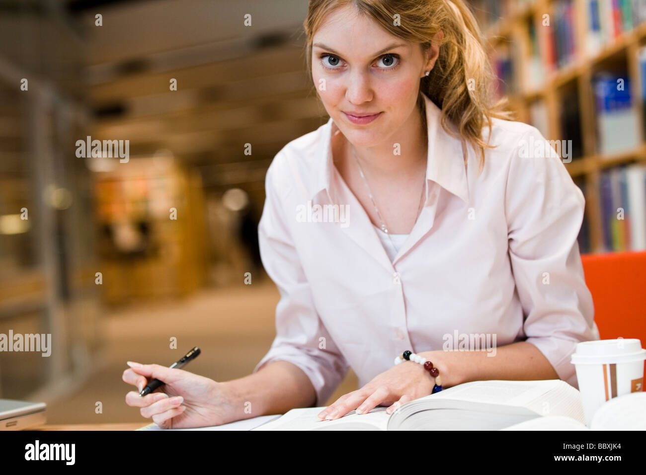 A female student studying in a library Sweden. Stock Photo