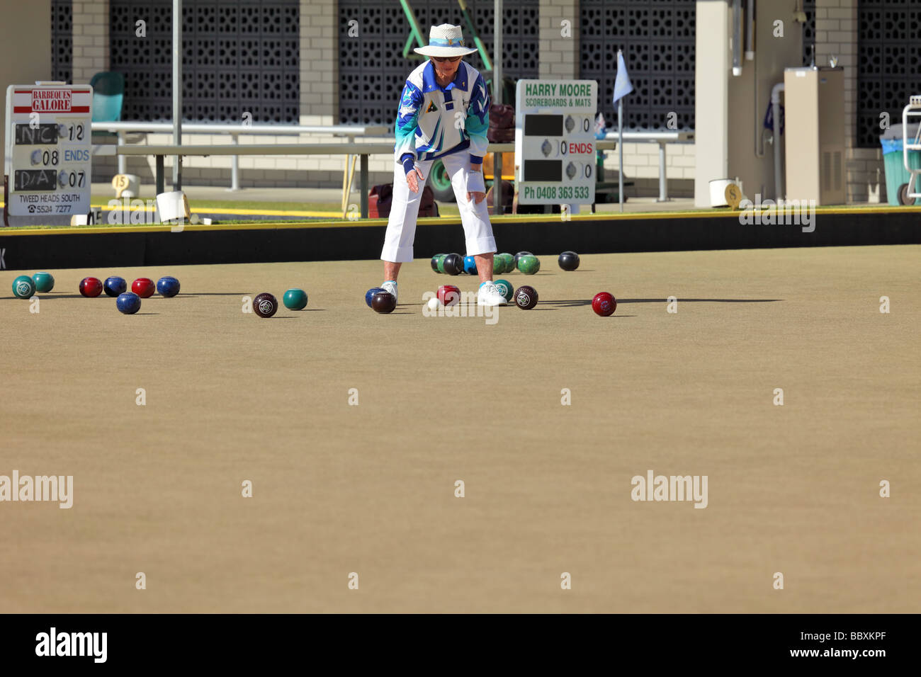 Woman at a lawn bowls tournament showing technique and bowling equipment Stock Photo