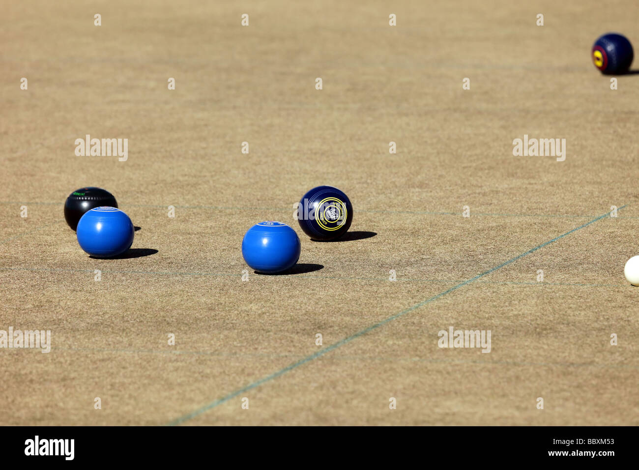 Woman at a lawn bowls tournament showing technique and bowling