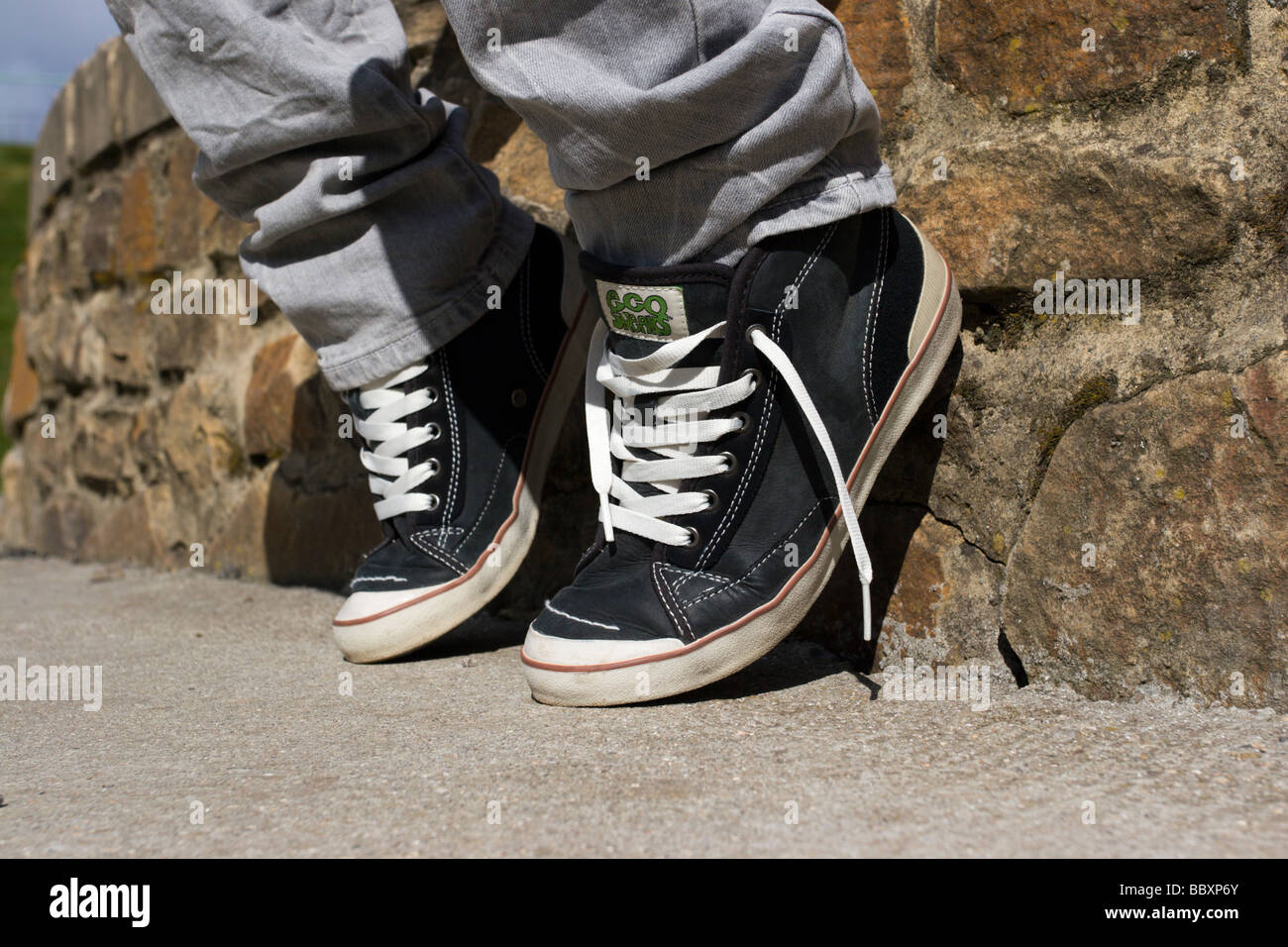 Youth Sitting on Wall Wearing Pumps Stock Photo
