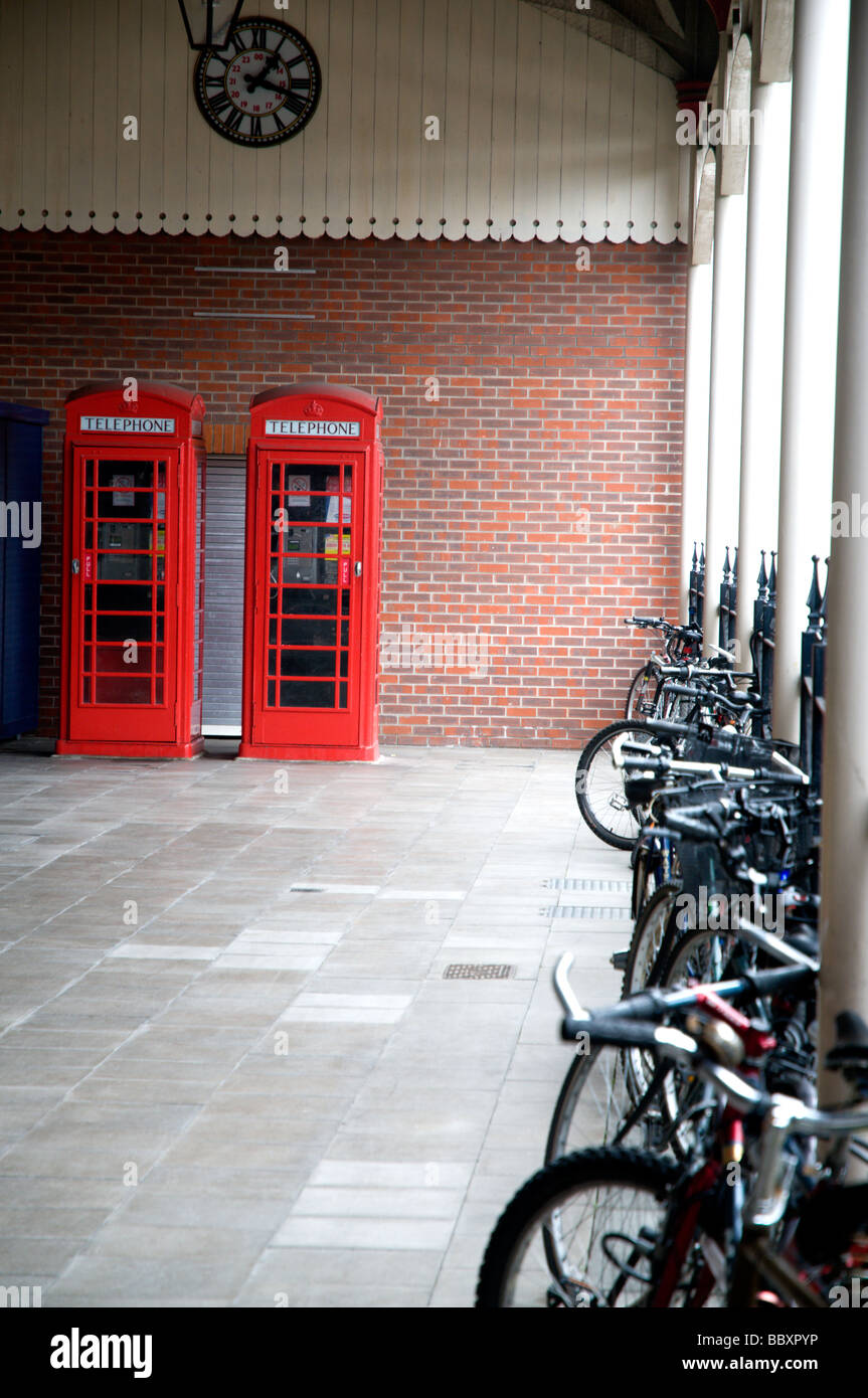 Two old red phoneboxes in Windsor train station. A row of cumuters bikes can be seen in the foreground. Stock Photo