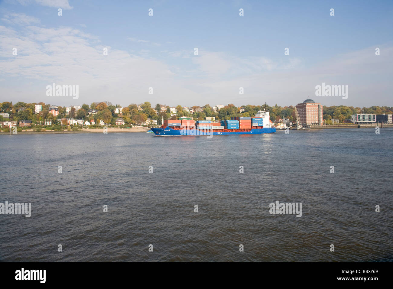 A small to medium size container ship heads out to see along the Elbe, Hamburg Stock Photo