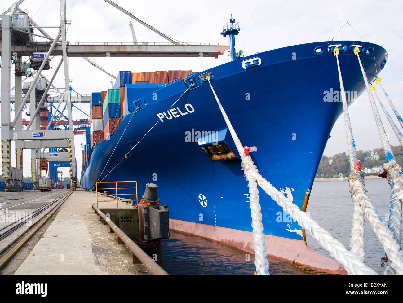 A docked and moored container ship waits to be unloaded at a container