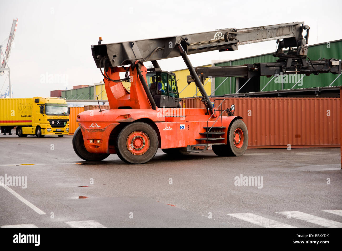 A large container forklift truck stacks and loads ISO containers at a