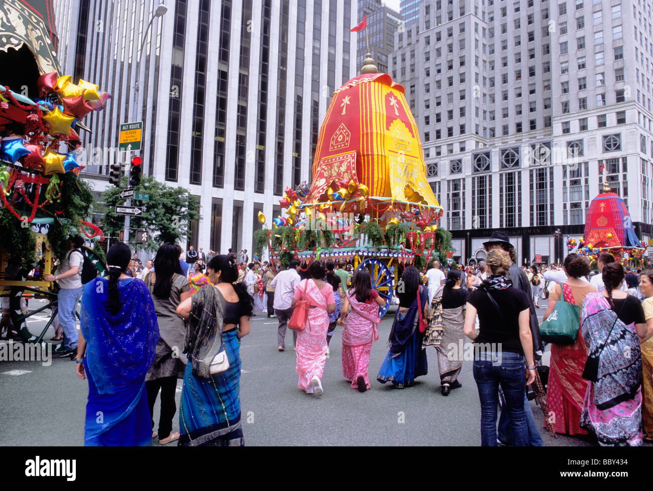New York City Hare Krishna procession on Fifth Avenue. Women in saris following the colorful floats in the parade. Bystanders watching on the street. Stock Photo