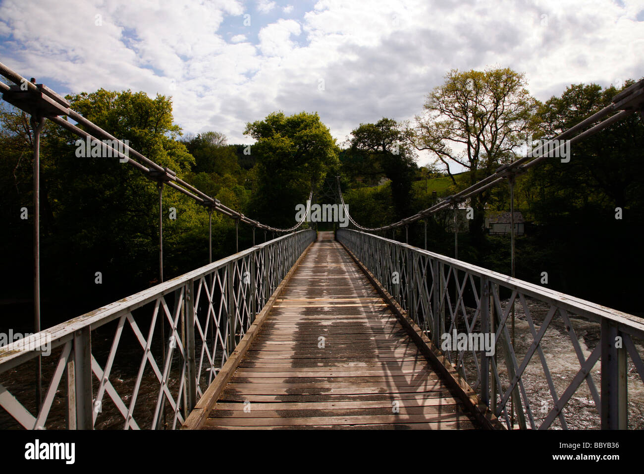 An old suspension bridge across the River Wye, close to the village off Llandeilo Graban near Builth Wells Stock Photo
