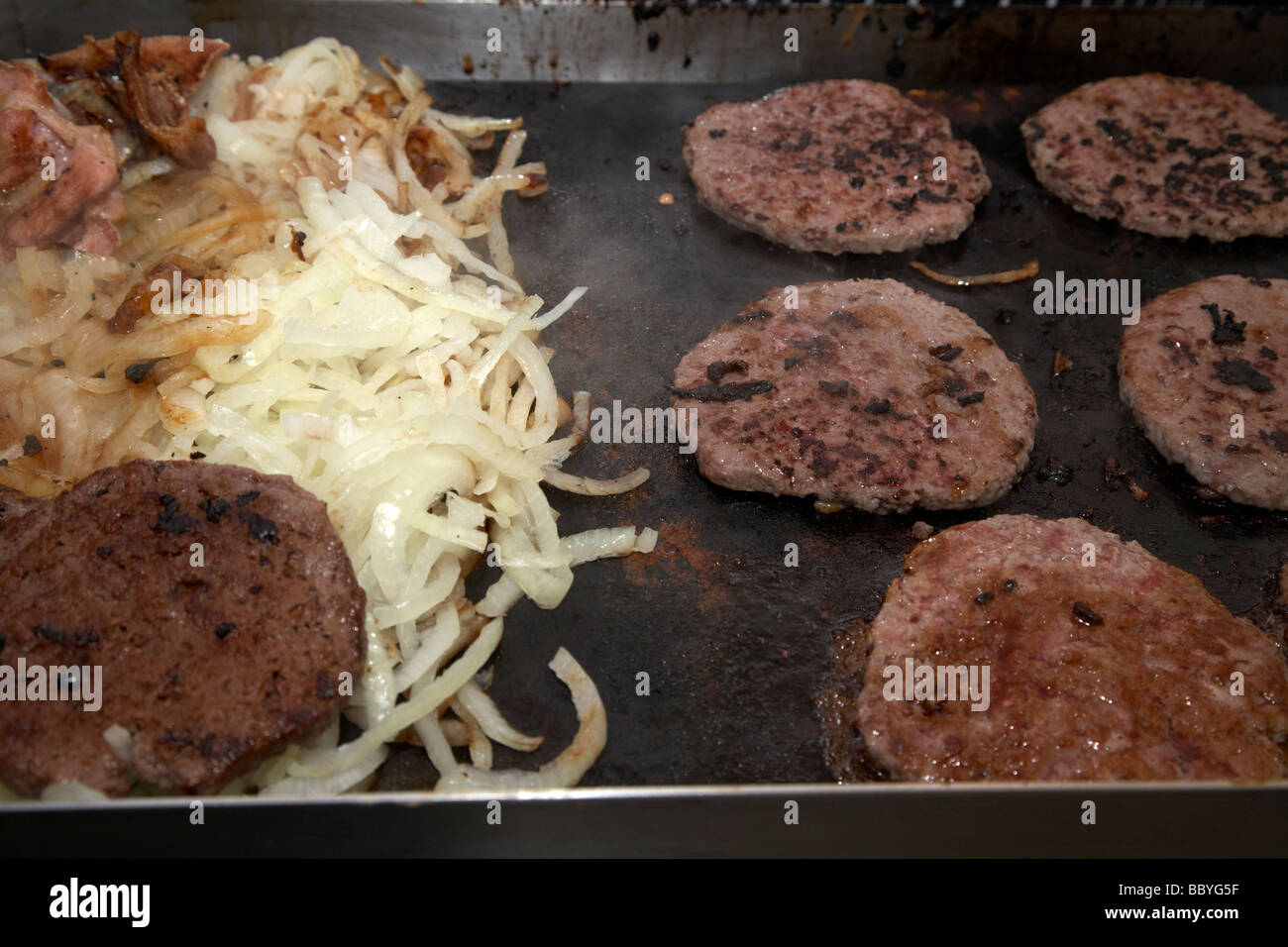 onions hamburgers being cooked on an open hotplate for sale at a public event county down northern ireland uk Stock Photo