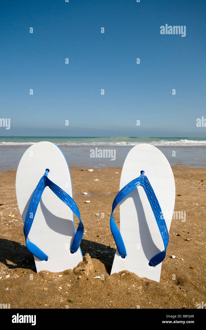 Flip flops and in sand on beach Stock Photo - Alamy