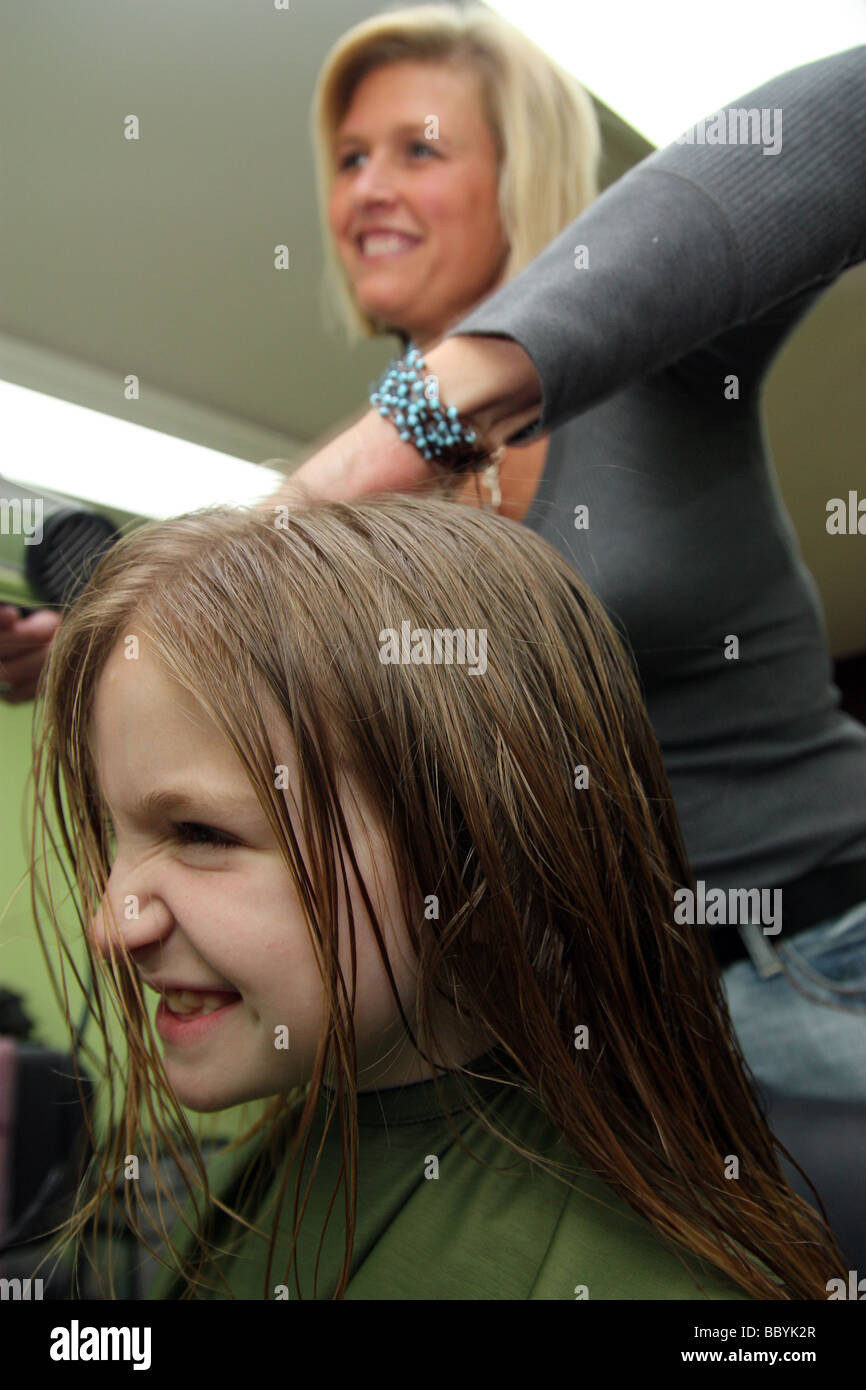 Stylist drying hair of a young client Stock Photo - Alamy