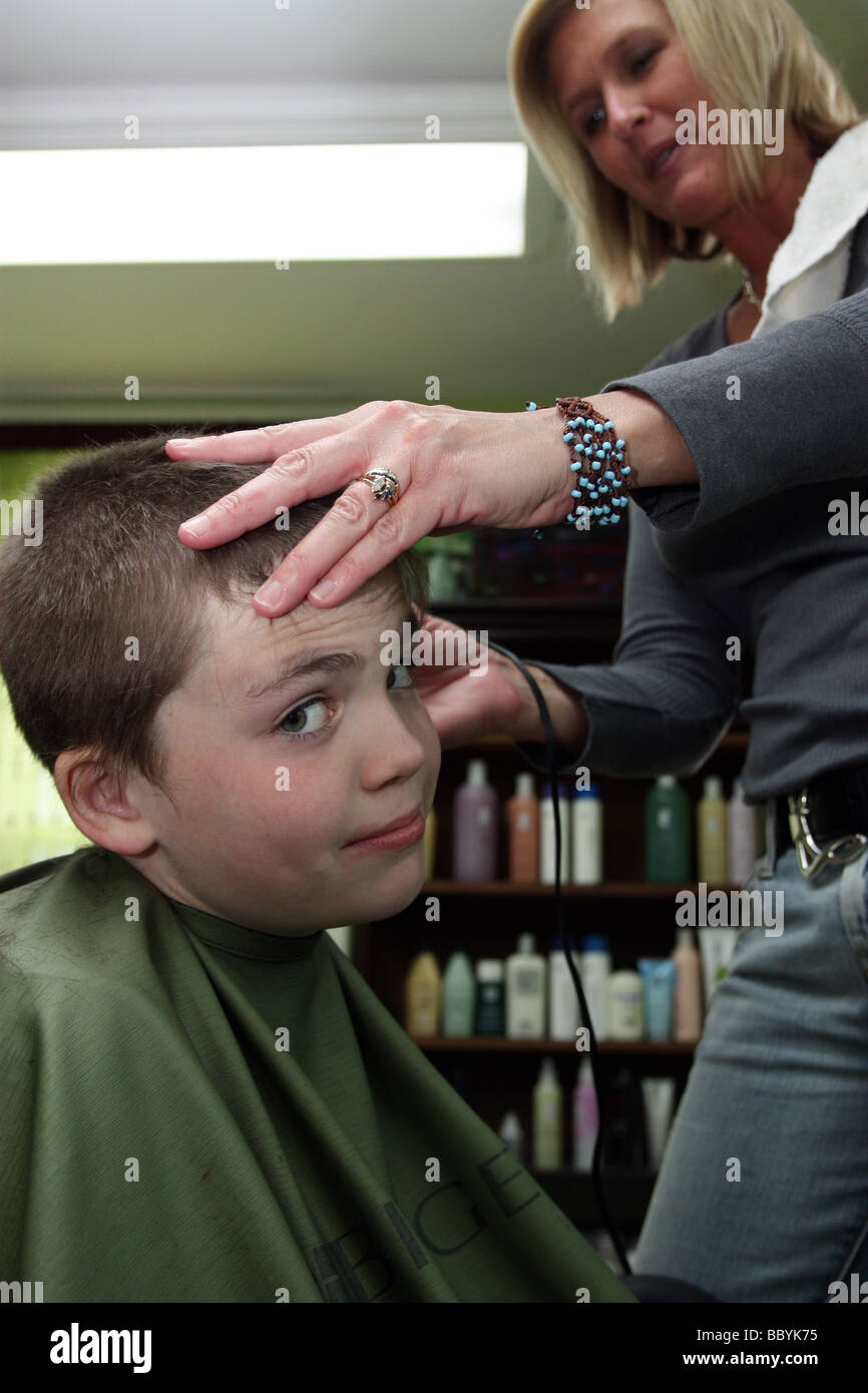 Not-so-enthusiastic boy getting a haircut Stock Photo