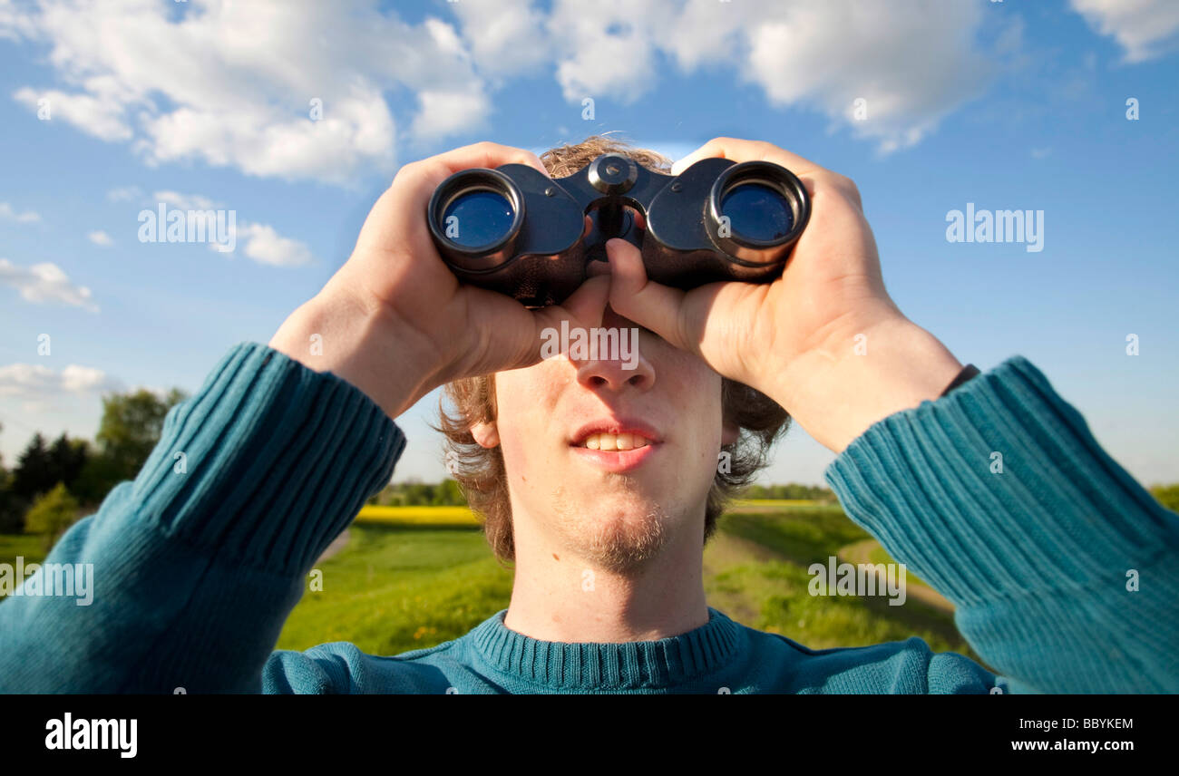 Young man use binoculars Stock Photo