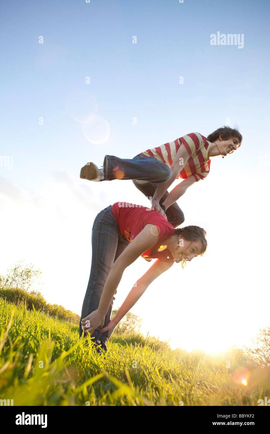 Young couple playing leapfrog Stock Photo