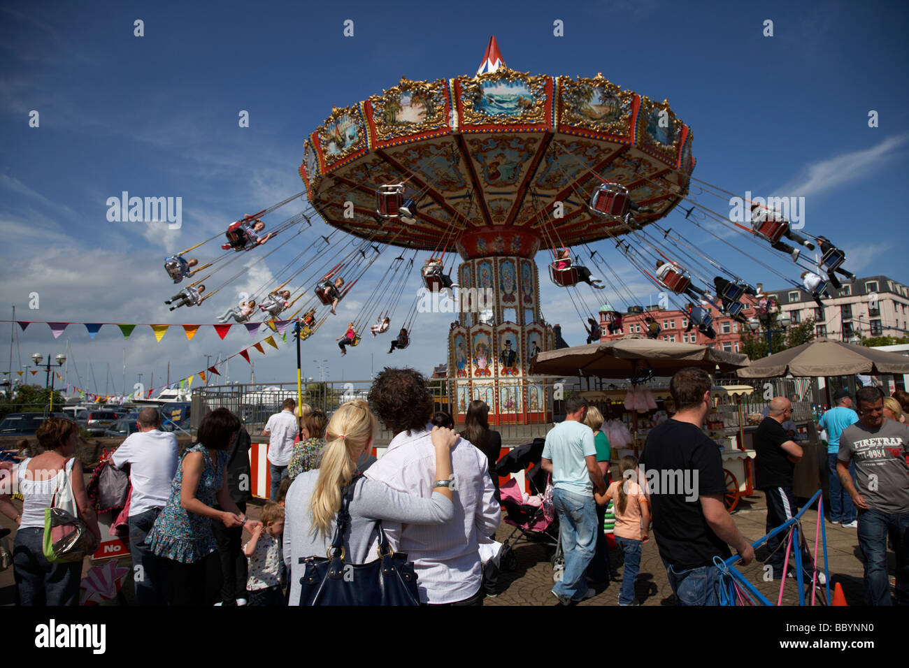 couple standing watching chair o plane fairground funfair ride bangor county down northern ireland uk Stock Photo