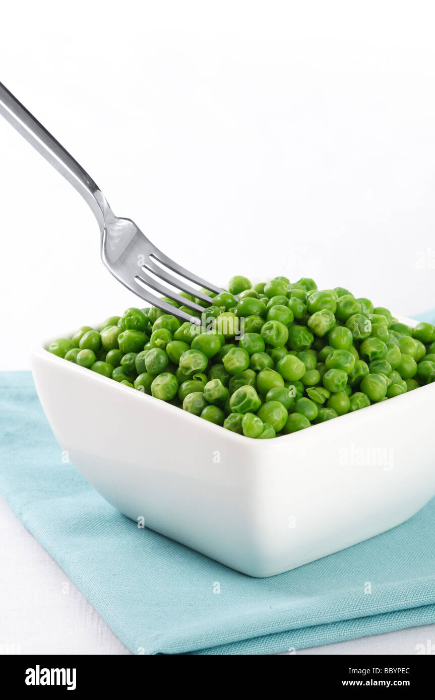 A bowl of green peas with a fork Stock Photo