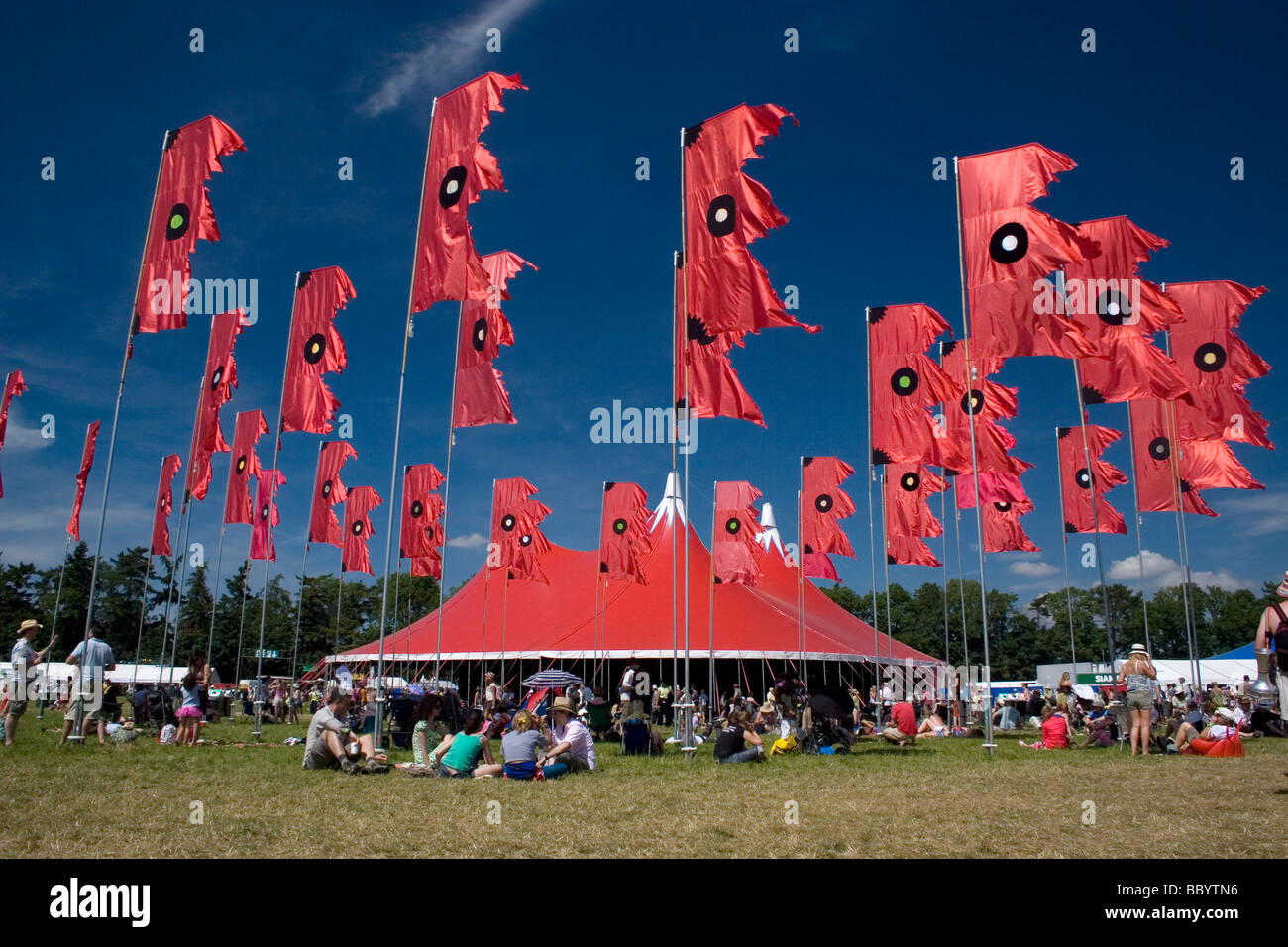 music tent and red flags blowing Womad festival England Stock Photo