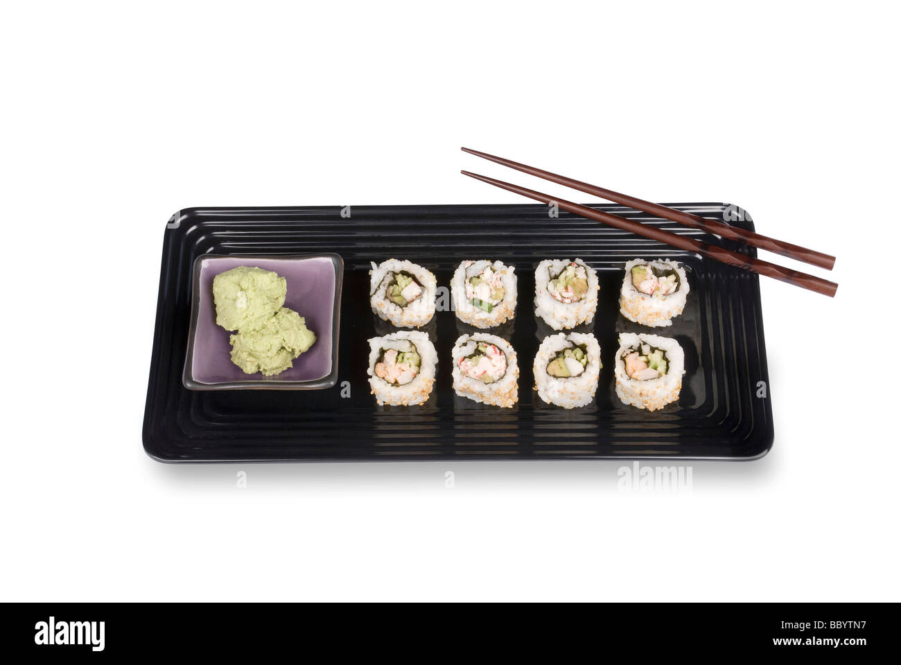 An elegant dish of crab and fish sushi rolls with wasabi sauce and chopsticks on a black serving tray Stock Photo