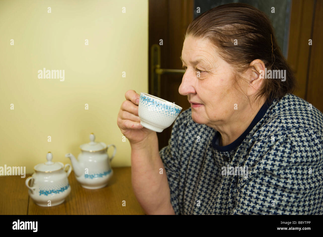 Woman, 67 years old, drinking tea in the kitchen Stock Photo
