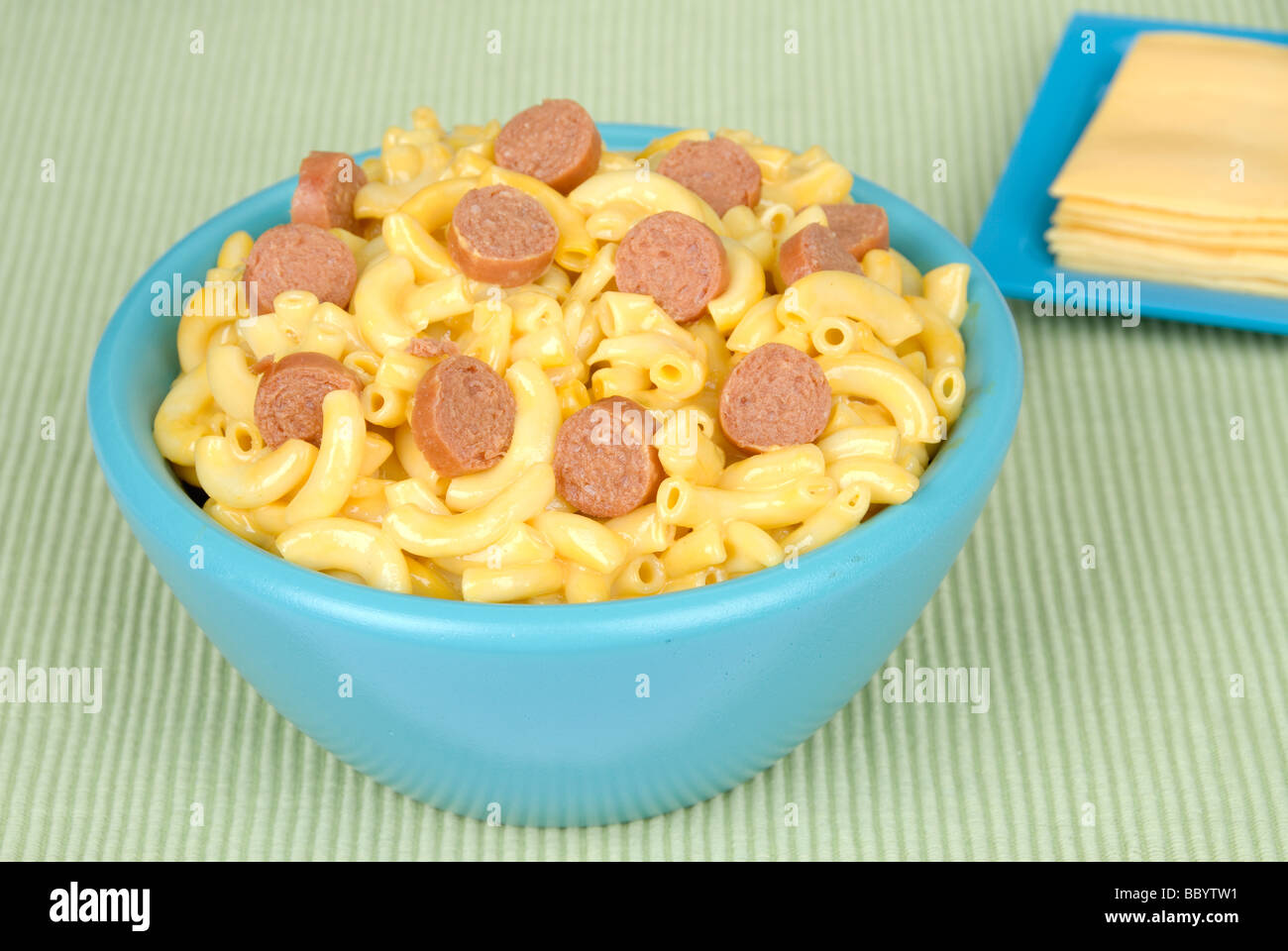 A bowl of macaroni and cheese with hotdogs bits and sliced cheese Stock Photo