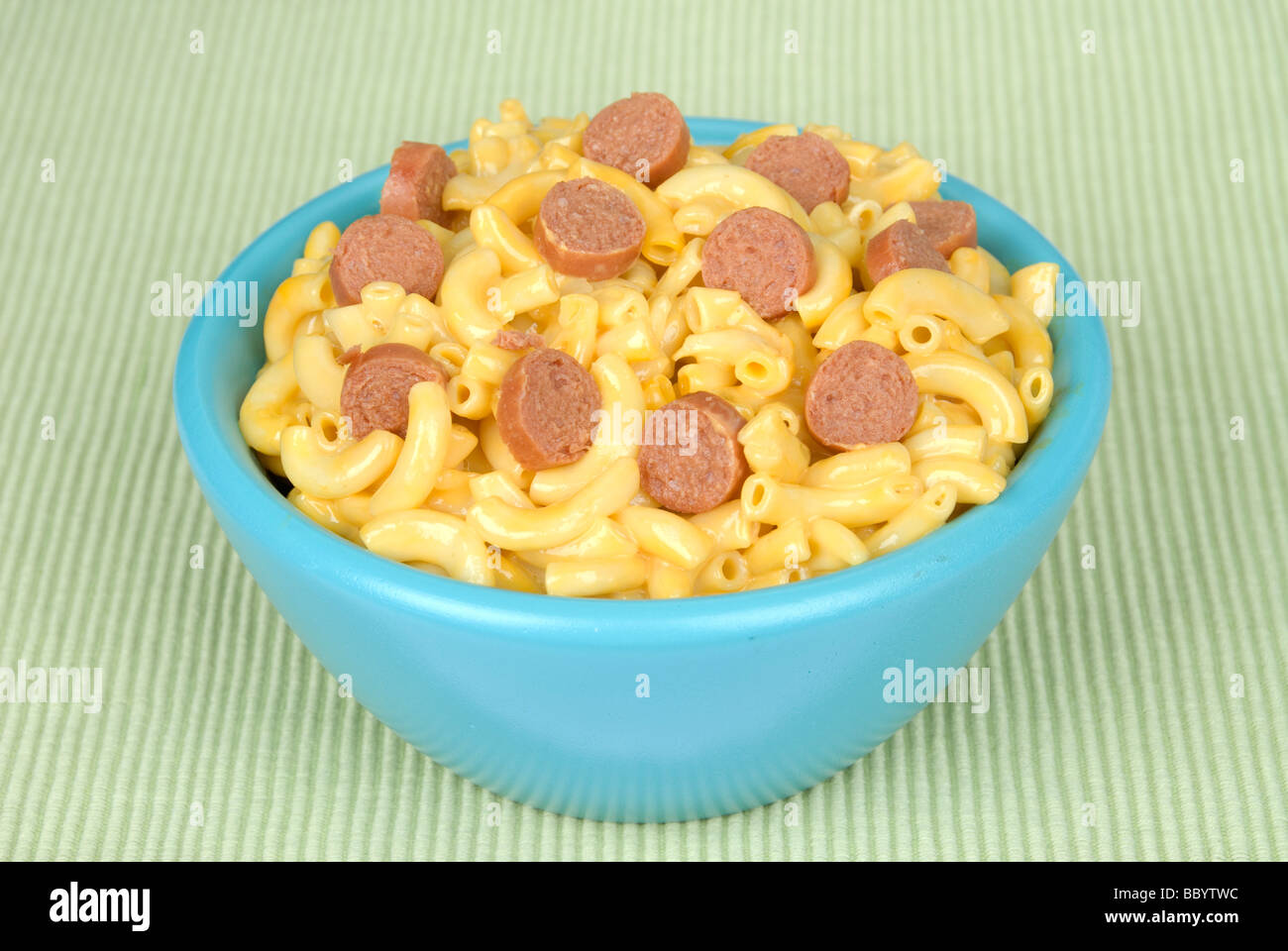 A bowl of macaroni and cheese with tasty hotdog slices Stock Photo