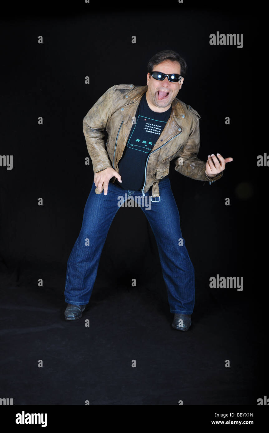 Funny, devoted man plays the Air Guitar, dressed in his Leather jacket Stock Photo