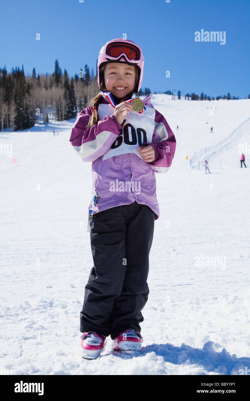 Mixed race girl showing off skiing medal Stock Photo