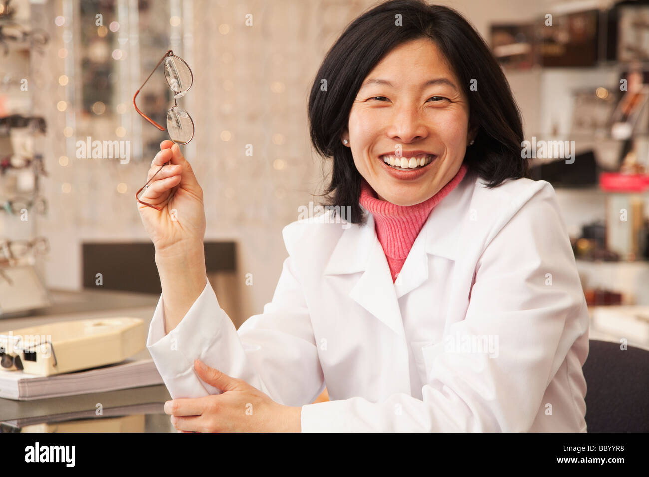 Korean optician holding eyeglasses Stock Photo