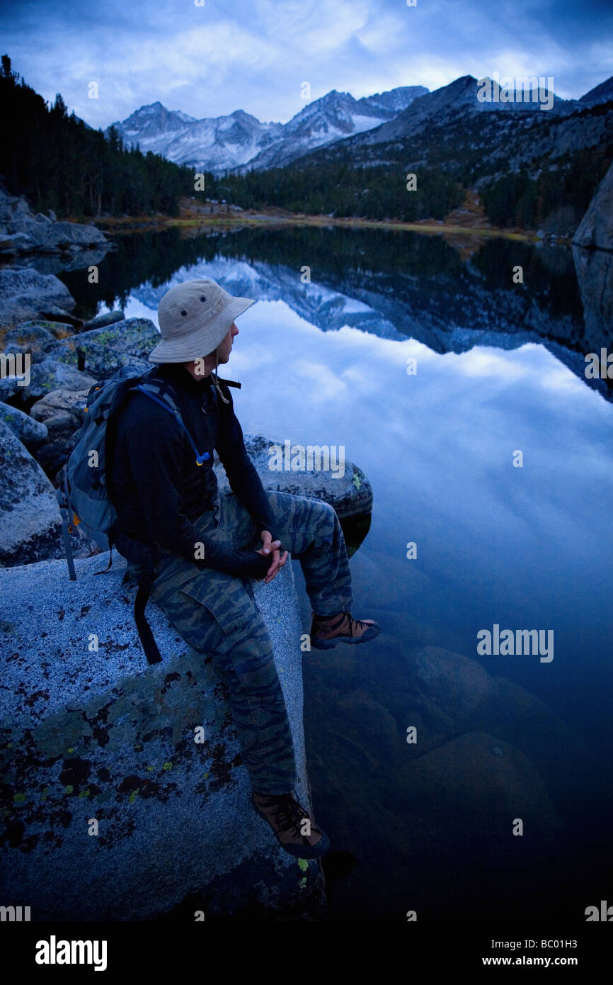 Hiker resting by a lake. Stock Photo