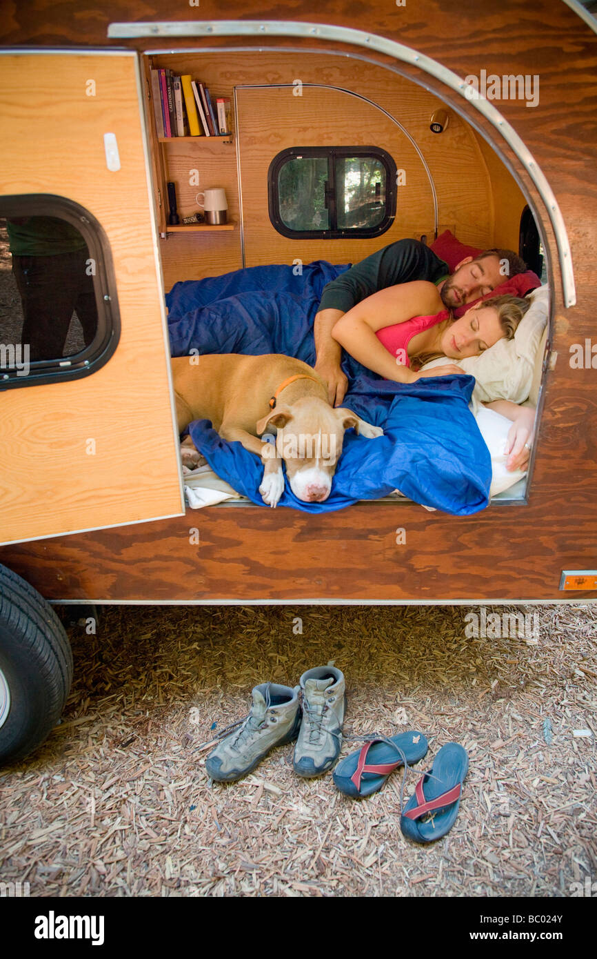 A young couple with their dog camping in a trailer near Big Sur. Stock Photo