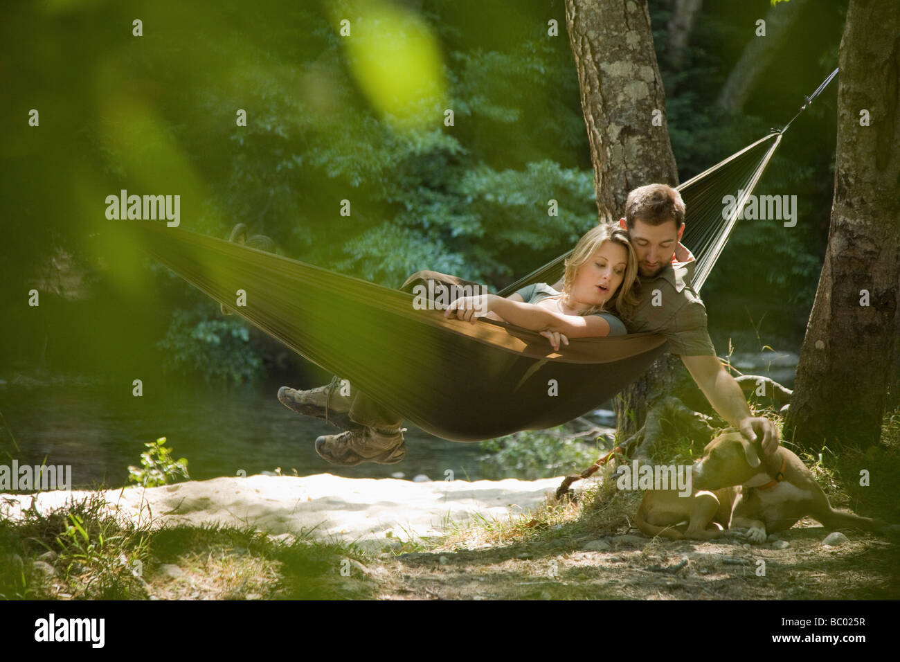 Couple relaxing in a hammock in the woods. Stock Photo