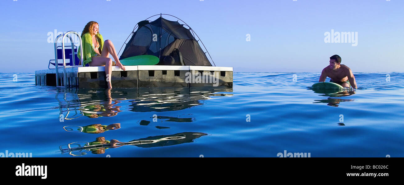 Couple camping on a floating platform in the ocean. Stock Photo