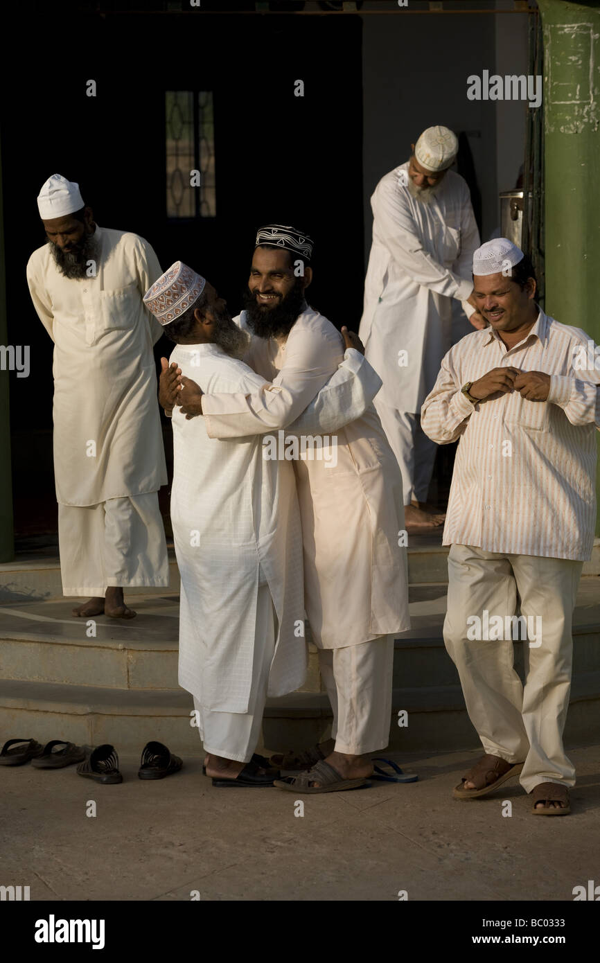 Muslim men exchange warm greetings after prayer. Goa, India. Stock Photo