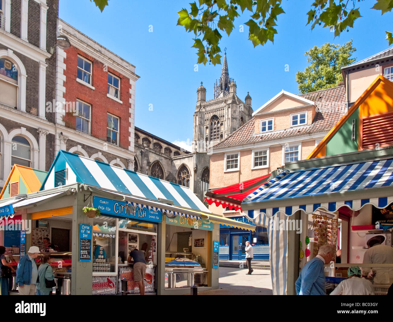 Corner of Norwich Market showing St Peter Mancroft Medieval Church, market stalls & Old buildings Stock Photo
