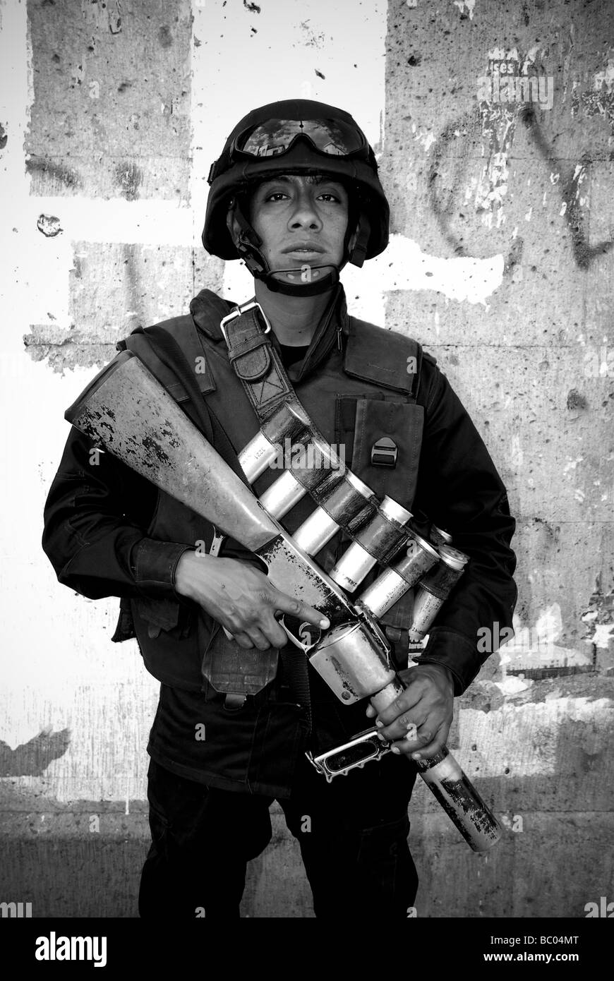 A uniformed soldier stands guard armed with a tear gas launcher in Oaxaca, Mexico. Stock Photo