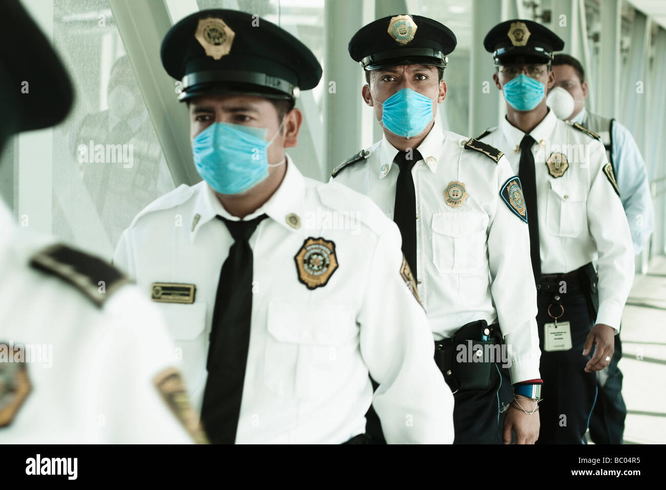 Policemen walking at the airport wearing blue masks. Mexico city, DF, Mexico. Stock Photo