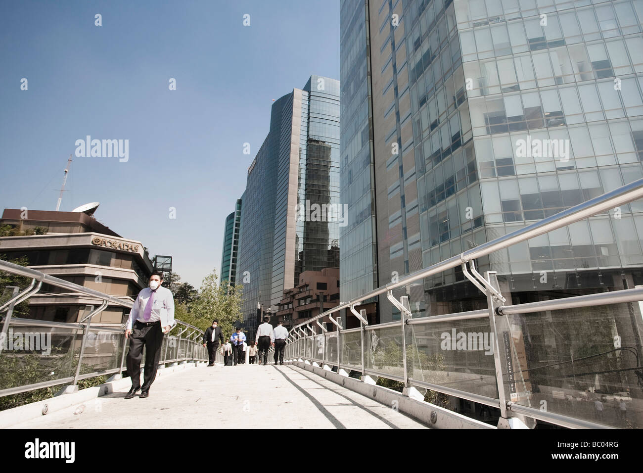 People walk through a pedestrian bridge  wearing mask during the swine flu epidemic in Mexico City, DF, Mexico. Stock Photo