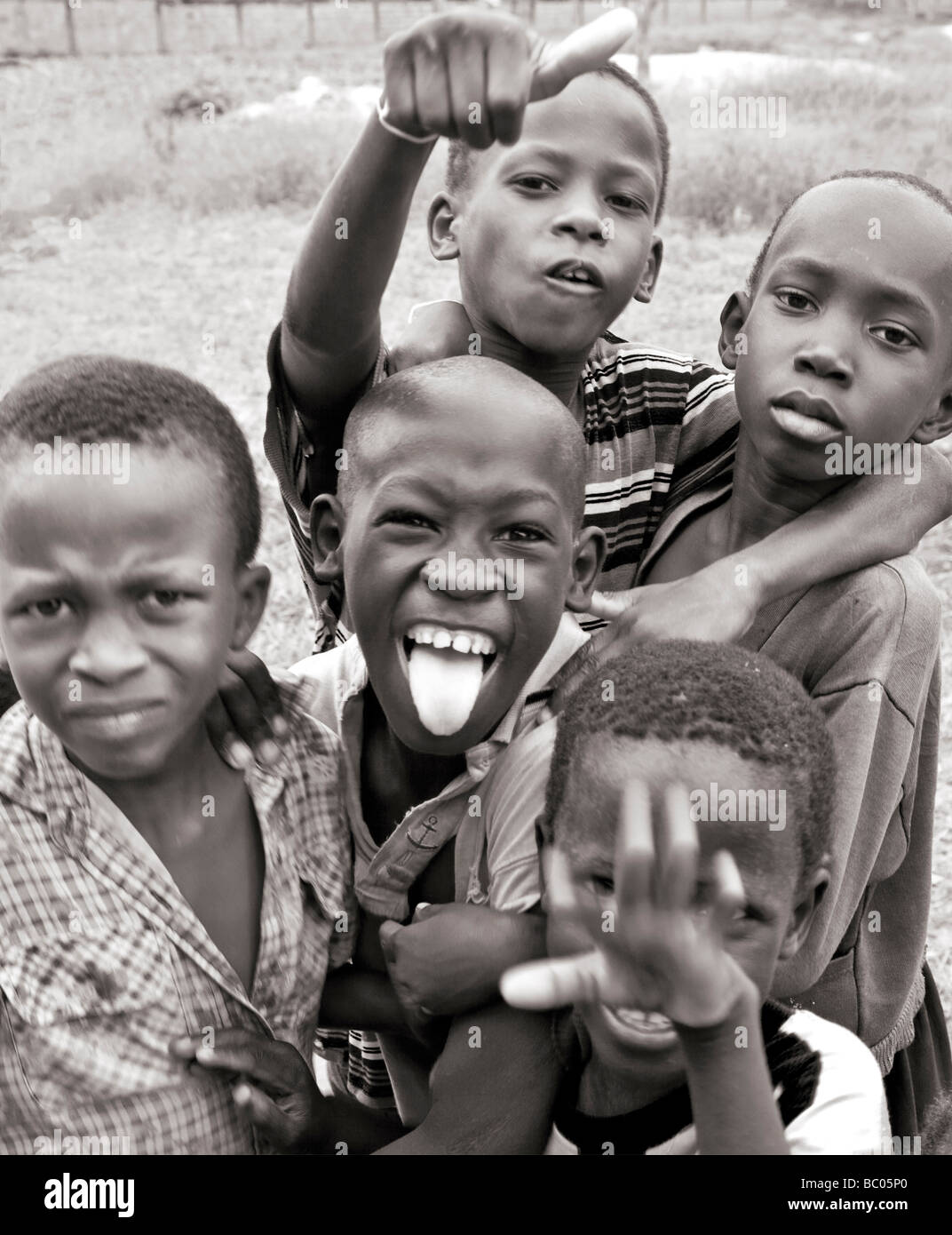 Black and white photograph of gambian african boys pulling faces and messing about for the camera