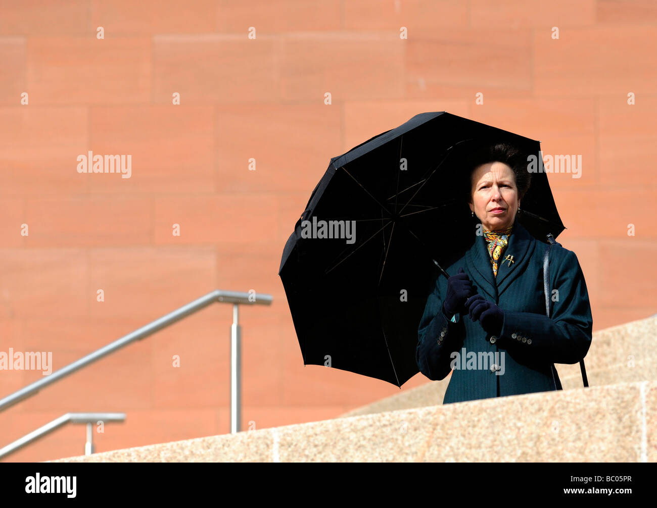 HRH Princess Anne, the Princess Royal shelters from a rain shower ...