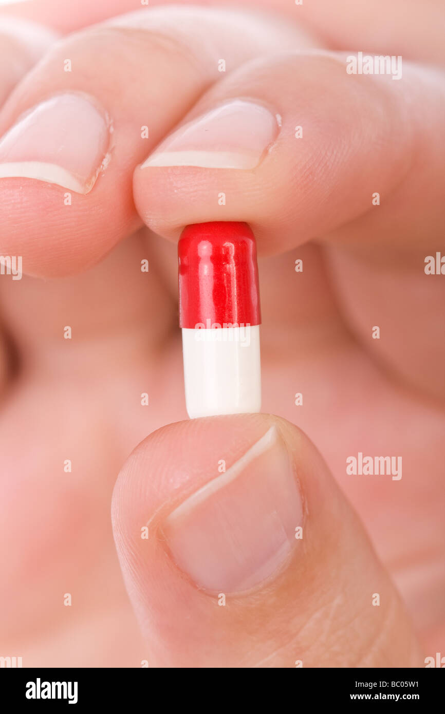 Hand holding a capsule or pill close up Stock Photo Alamy
