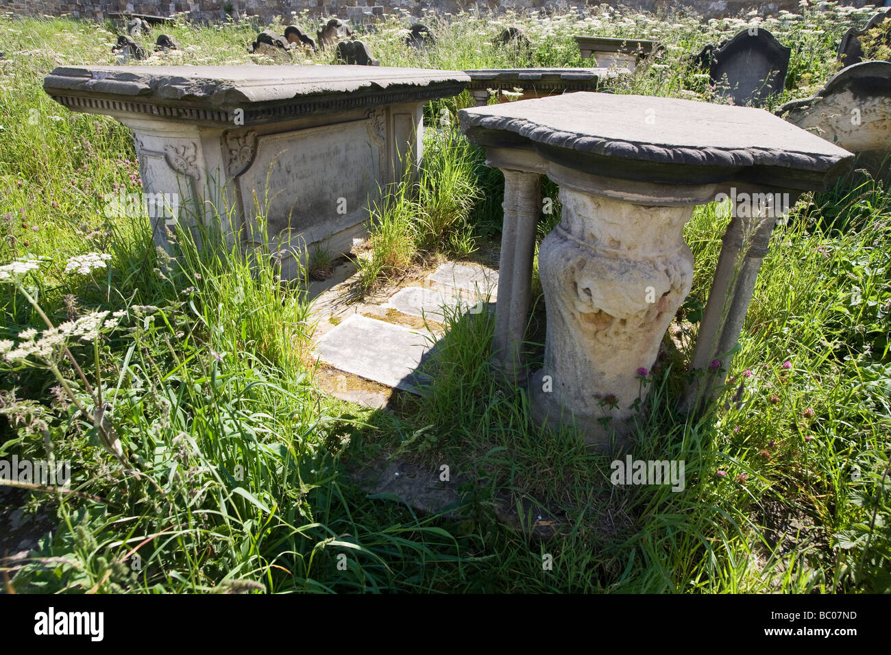 Victorian tomb stones in churchyard overgrown with weeds Stock Photo