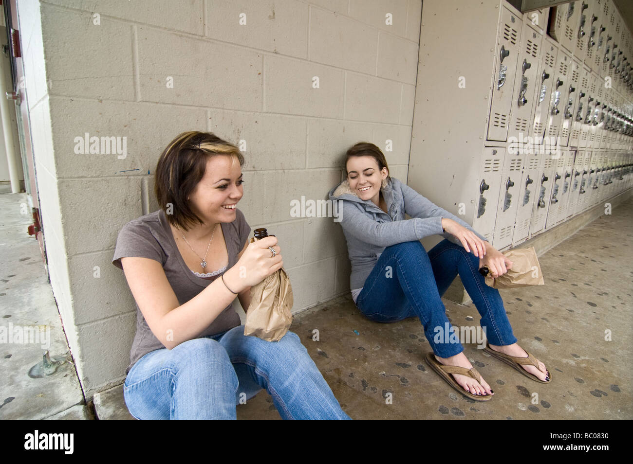 Twins girls getting drunk drinking alcohol at their high school Stock Photo