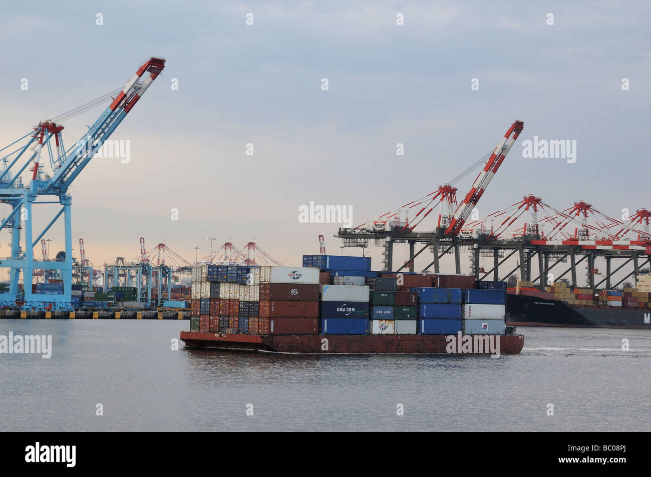 Gantries and a barge loaded with containers in the Port of New York and ...