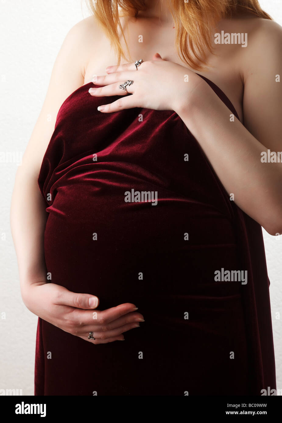 pregnant woman holding her belly over white background Stock Photo