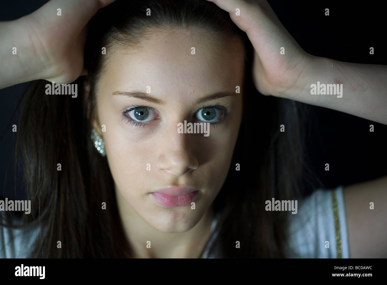 Young teenage girl hair back serious face only - aged fourteen Stock Photo