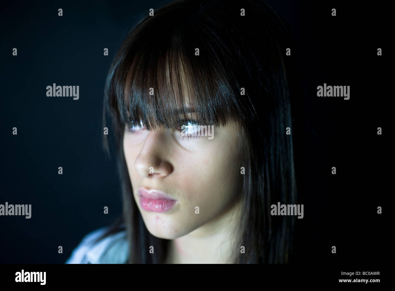 Young teenage girl side profile of face with concerned sideways glance aged fourteen Stock Photo